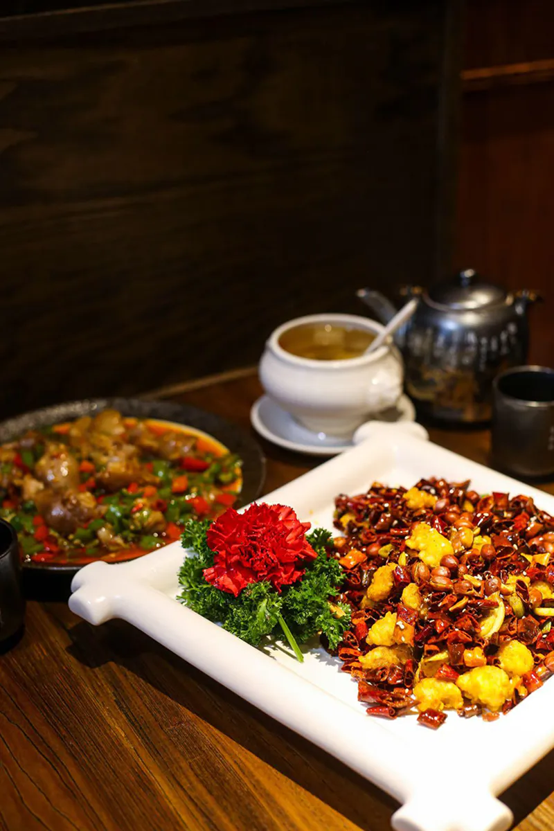 Spicy dishes with soup, decorated with a flower at Szechuan Gourmet, a Chinese Restaurant in New York